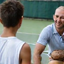 Tennis coach giving advice to a young player